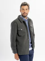 Sobrecamisa de paño color gris, de corte recto, con cuello camisero, bolsillos con solapa en el pecho y cierre frontal con botones a presión.