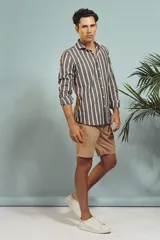 Camisa de manga larga en color salmón con estampado de pequeños motivos geométricos oscuros, cuello clásico y cierre frontal con botones.