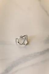 Anillo ajustable de acero quirúrgico hipoalergénico, color plateado, con diseño orgánico y calado.