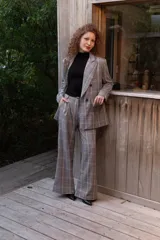 Pantalón sastrero de tiro alto con estampa a cuadros en tonos grises, rojos y blancos, de corte recto y holgado.
