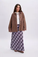 Campera de jean color marrón con efecto lavado, cuello camisero, cierre frontal con botones y bolsillos laterales.