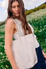 Cartera tipo shopper de cuero en color crudo, sin forro y con terminaciones al corte. Cuenta con gran capacidad y un bolsillo interior con cierre.