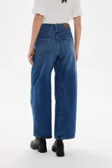 Pantalon de jean estilo barrel con tiro alto y bolsillos laterales. Presenta un corte amplio y relajado en las piernas con un lavado azul clásico.