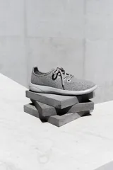 Zapatilla de diseño minimalista confeccionada en lana merino, con cordones al tono y suela de EVA. Presenta un estilo atemporal y versátil, ideal para uso diario.