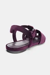 Sandalia plana tipo cangrejera confeccionada en material con efecto terciopelo. Presenta diseño de tiras entrelazadas, punta redonda y cierre mediante hebilla metálica lateral.