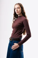 Camiseta de ajuste entallado, color bordó, con cuello alto y mangas largas.