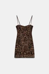 Vestido mini de tul con estampado animal print, diseño tipo corsetero con aros en el busto, tirantes finos ajustables y costuras marcadas verticales.