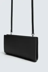 Cartera tipo bandolera de color negro con acabado texturizado. Cuenta con un compartimento principal con cierre de cremallera, interior con dos compartimentos adicionales y asa de hombro ajustable y extraíble.