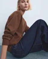 Jeans de denim azul oscuro con diseño de tiro medio y corte ancho en las piernas, con bolsillos delanteros y traseros.