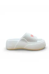 Chancletas blancas de plataforma con faja ancha y suela de goma. Tienen detalles en color salmón en la faja y suela tostada.