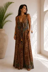 Vestido largo y fluido con estampado animal print combinado con detalles paisley en tonos turquesa. Cuenta con escote en V ajustable con tiras terminadas en borlas en el frente y tirantes regulables en los hombros.