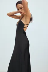 Vestido midi de tejido satinado color negro, con escote en pico, tirantes finos ajustables y diseño de espalda con tiras cruzadas.
