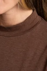 Polera de manga larga color marrón jaspeado, con cuello alto y corte ajustado al cuerpo.