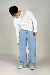 Pantalón jean celeste de corte amplio, estilo cargo, con bolsillos laterales y traseros.