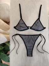 Conjunto de bikini de dos piezas en color plateado con acabado metálico y textura acanalada. El corpiño es de corte triangular con ribetes negros y una argolla central metálica. La bombacha es de corte colaless con tiras laterales ajustables y ribetes negros.