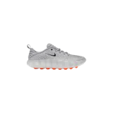 Championes Nike Mind 002, color gris claro, con diseño perforado en la parte superior, logo Swoosh metálico en el lateral y suela con tacos naranjas.
