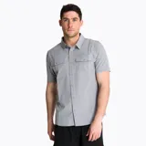 Camisa de manga corta Merrell modelo Akaroa, de color gris melange, con cierre frontal de botones, cuello camisero y bolsillos frontales con solapa en el pecho.