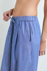 Pantalon de corte holgado y tiro medio, confeccionado en algodón con diseño de rayas verticales finas en color azul y blanco.