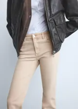 Jeans tiro medio color beige con diseño flare y bajo deshilachado, con cierre de cremallera y botón, trabillas y cinco bolsillos.
