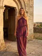 Vestido largo bordó de gasa con escote halter y volados diagonales metalizados.