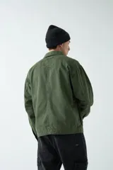 Campera negra de canvas de algodón grueso con bolsillos con cierre y botones a presión.