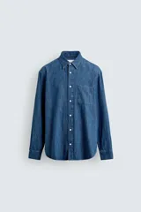 Camisa regular fit de denim de algodón azul, con cuello solapa, manga larga con puños abotonados, un bolsillo de parche en el pecho y cierre frontal de botonadura.