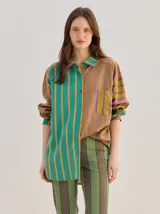 Camisa de algodón liviano con diseño de rayas multicolor, corte holgado, cuello camisero, mangas largas y bolsillo frontal.