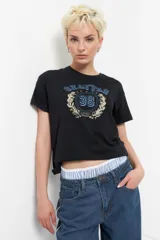 Remera azul marino de algodón con cuello redondo y mangas cortas. Estampa frontal con la palabra "Seattle" en arco, número 38 dentro de un círculo y estrellas.