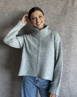 Sweater color crudo de cuello alto con mangas largas y corte holgado.