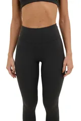 Calza larga negra de compresión media, con cintura alta de doble tela y corte en la parte posterior.