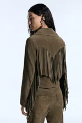 Campera de gamuza color verde militar, de corte entallado, con cierre frontal y diseño de flecos largos en el delantero y la espalda. Presenta un canesú de inspiración western en la parte posterior.