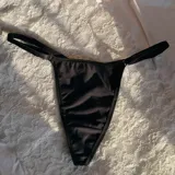 Tanga de hilo negra con tiras laterales regulables.