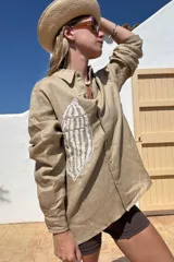 Camisa blanca de lino con bordado de pulpo azul en el pecho, de corte recto y manga larga.