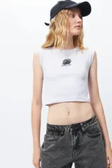 Top sin mangas negro, ajustado al cuerpo, con cuello redondo y tejido acanalado. Presenta un pequeño estampado frontal de una frutilla con el texto "berry cute".