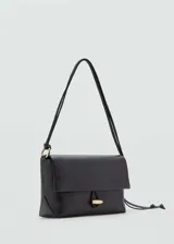 Bolso de hombro pequeño en color negro, con diseño estructurado y cierre de solapa con botón joya metálico. Presenta un asa larga con nudo ajustable en uno de los laterales.
