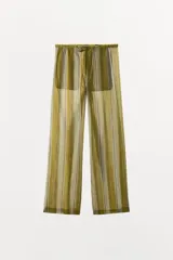Pantalón ZARA Woman Collection confeccionado en mezcla de lyocell, con diseño de rayas verticales en tonos verde oliva y beige. Presenta tiro medio, cintura ajustable con cordón y perneras rectas.