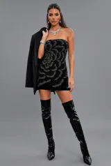 Vestido corto strapless de terciopelo negro, decorado con pedrería formando un diseño floral.