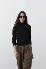 Polera de manga larga y cuello alto, confeccionada en tejido de punto fino, con un ajuste ceñido al cuerpo.