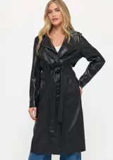 Trench largo de cuero sintético negro con solapas anchas, cierre frontal cruzado y cinturón ajustable en la cintura. Presenta detalles de tejido acanalado en la zona de la cintura y bolsillos laterales.