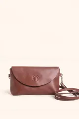 Cartera tipo sobre de cuero color marrón, con solapa frontal redondeada que presenta un detalle circular grabado. Incluye correa larga ajustable y extraíble, cierre principal y broche de seguridad.