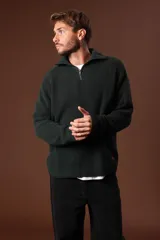 Sweater verde oscuro de punto con cuello alto y cierre de cremallera parcial. Tejido de canalé vertical.