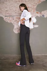 Calza negra de lycra gruesa, tiro alto y corte semi-oxford con abertura en el tobillo.