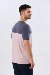 Remera de algodón y poliéster de corte clásico, con diseño en bloques de color negro en la parte superior y gris melange en la inferior. Presenta cuello redondo, mangas cortas y un pequeño estampado tipográfico en el pecho.
