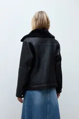 Chaqueta biker de cuero sintético negro con interior y solapas de piel sintética al tono. Presenta cierre frontal cruzado, mangas largas y textura granulada.