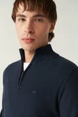 Sweater azul marino de punto con cuello alto y medio cierre con cremallera. Tiene mangas largas y logo bordado en el pecho. Corte regular.