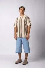 Remera de tejido de punto con diseño de rayas verticales en tonos beige y marrón, de manga corta y cuello redondo.