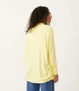 Cardigan alargado en tejido de punto color amarillo, con ribana en los puños y barra redondeada.