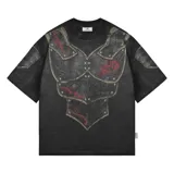 Remera de algodón con efecto acid wash y corte boxy fit. Presenta un estampado frontal que simula una armadura medieval con detalles en rojo y remaches, extendiéndose hacia las mangas.