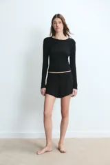 Short de tiro medio confeccionado en tejido de viscosa con elastano, de corte holgado y cintura elástica con cordón de ajuste.