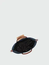 Bolso de viaje Longchamp modelo Le Pliage Original, de diseño ampliable, confeccionado en nylon negro con detalles en cuero marrón en las asas y solapa frontal con cierre de botón a presión. Incluye correa ajustable y extraíble.